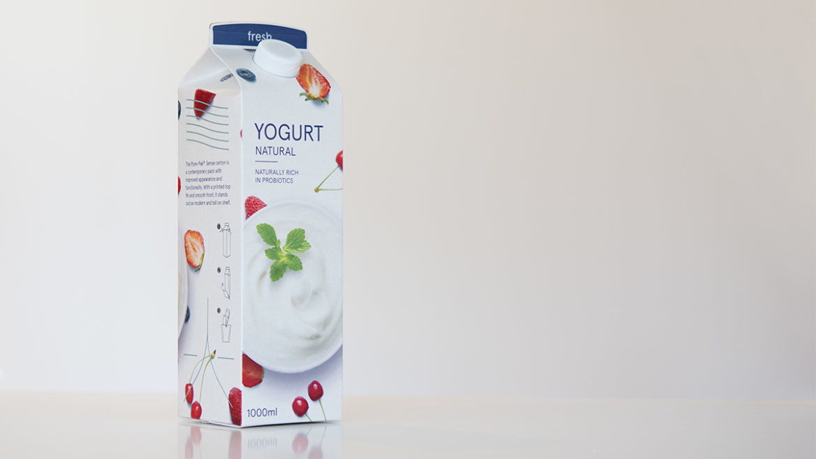 A 1-liter carton of natural yogurt with printed fruits and a bowl of yogurt on a light background.