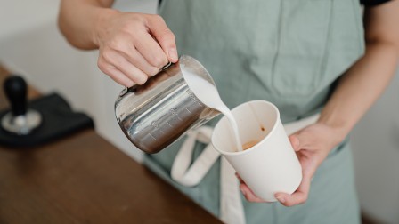 Sustainable packaging Barista pours coffee in a paper cup