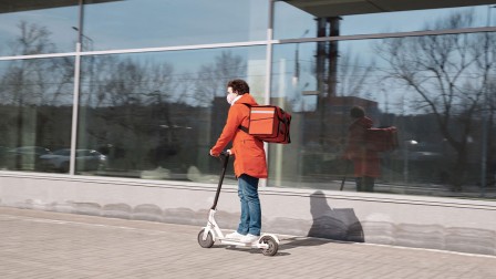 Lieferservice während Corona Mann liefert Essen auf E-Scooter aus