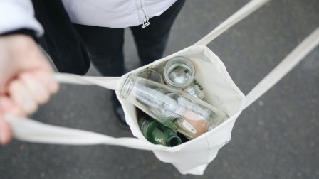 Glasflaschen in Stoffbeutel Person hält Stoffbeutel mit Glasflaschen auf