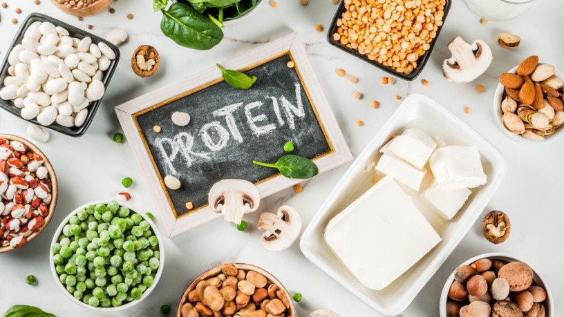 Erbsen, Sojabohnen und Ackerbohnen liegen auf einem Holztisch – natürliche Zutaten als Grundlage alternativer Proteine.