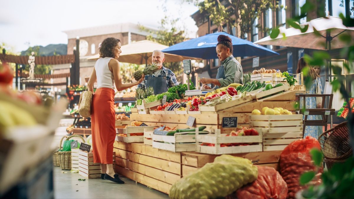 People at a market sampling plant-based protein products; a stand showing sustainable food alternatives.