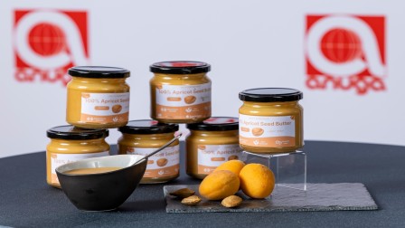 Gläser mit Aprikosenkernbutter werden auf der Anuga 2025 präsentiert. 