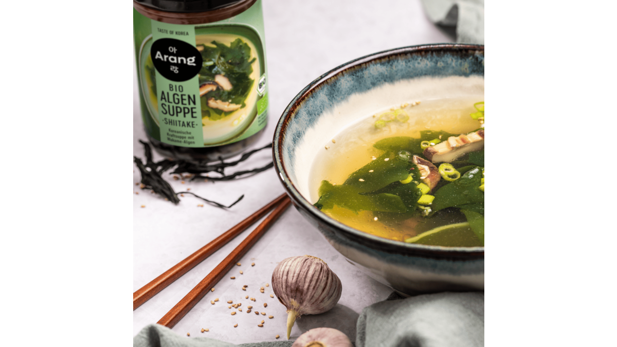 Eine Schüssel Algensuppe mit Shiitake-Pilzen auf dem Tisch, daneben Stäbchen und das gleichnamige Produkt von Arang – repräsentativ für koreanische Küche. Fermentiertes Gemüse, Tofu-Gerichte, natürliche Würzmittel und die Tempelküche zeigen, wie pflanzenbasiert koreanische Küche sein kann. Ich bin sicher, dass dieser Bereich stark wachsen wird.