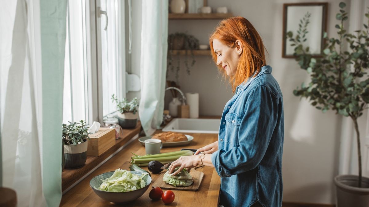 A bright, modern kitchen scene with a minimalist meal made from fresh vegetables, grains, and herbs, symbolizing the 2026 clean eating trend.