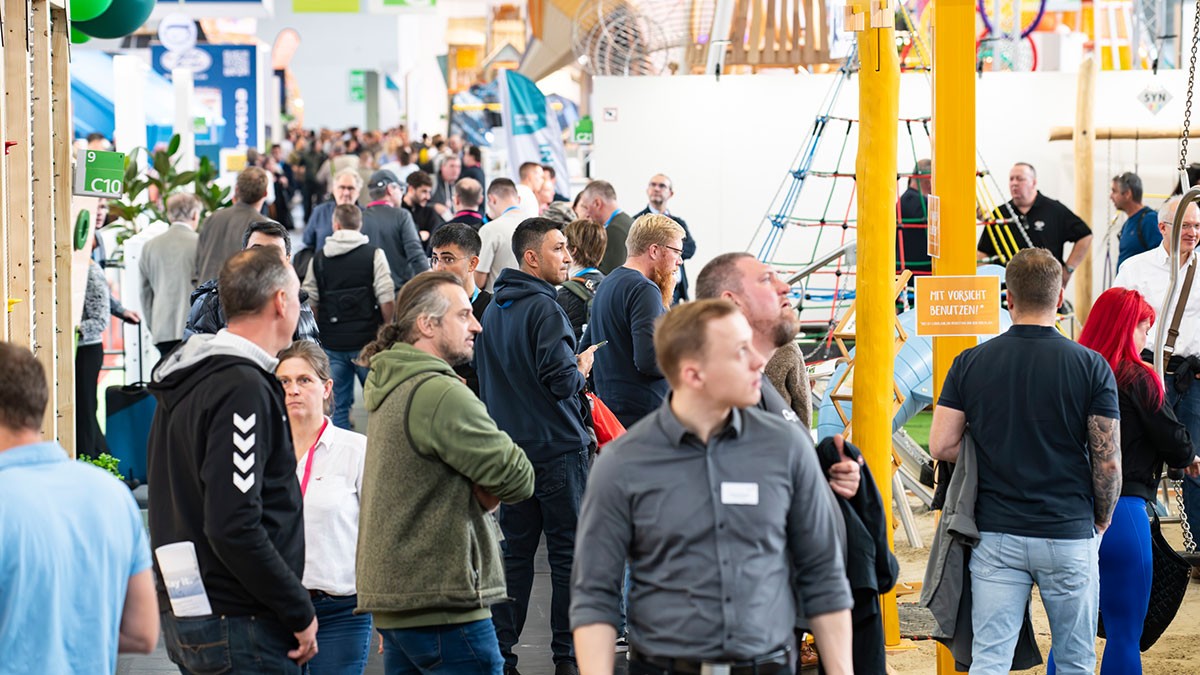 Visitors walk through a busy exhibition hall at Koelnmesse during FSB 2025, exploring various exhibitor booths and products.