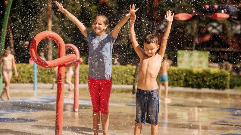 Kinder auf einem Wasserspielplatz