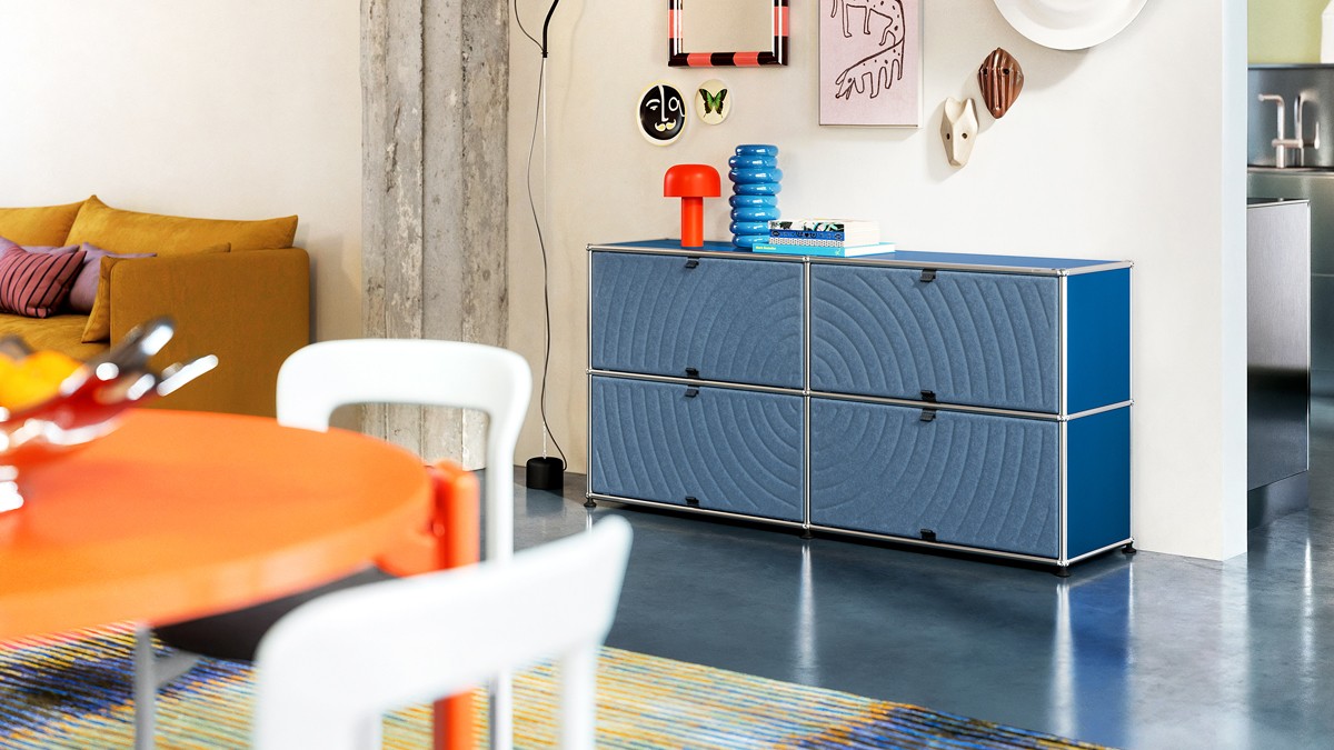Blue USM Haller sideboard with acoustic panels in a bright, stylishly furnished room in mid-century modern style.