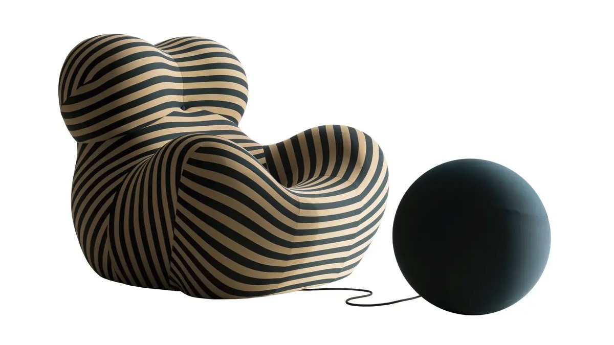 Wide black and white striped armchair with matching black, round footrest.