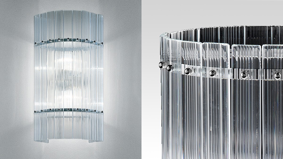 Wall lamp made of vertical glass rods with a shiny metal frame.