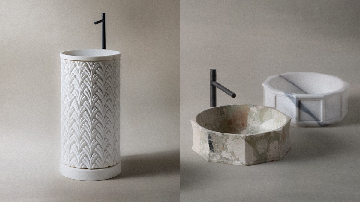 Marble washbasins by Kreoo with sculptural shapes and black faucet.