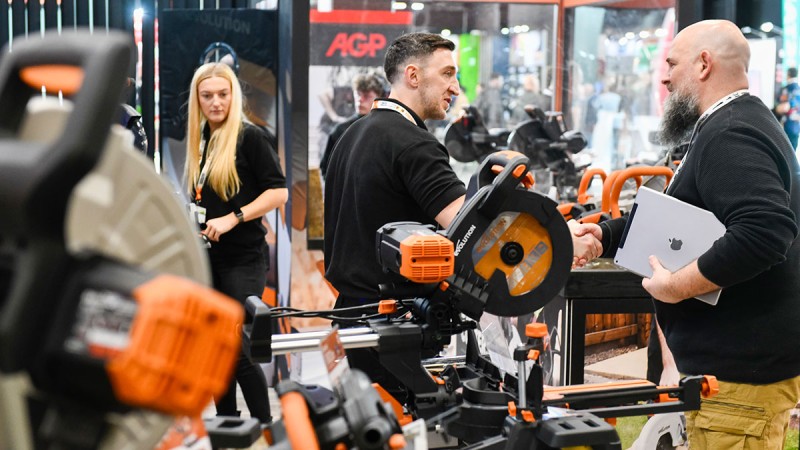 Three people hold a technical discussion at the EISENWARENMESSE - International Hardware Fair