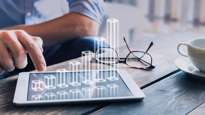 Tablet lying on a table with a visualised bar chart on which a person is working