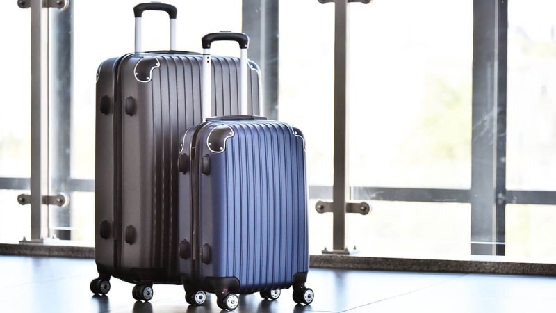 Zwei Rollkoffer stehen in einer Halle