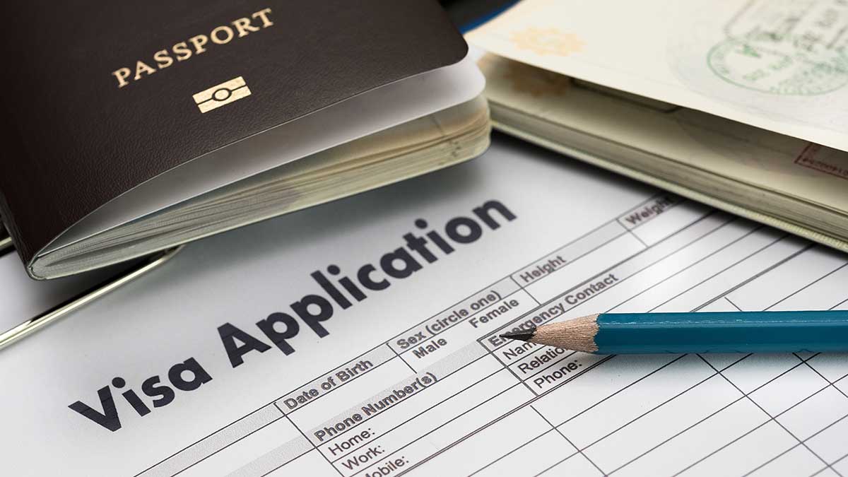 Form labelled ‘Visa application’ with a green pen and a passport on it