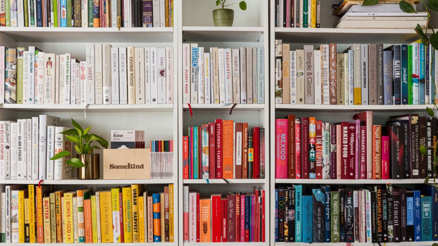 Großes Bücherregal Großes Bücherregal mit Büchern, die nach Regenbogenfarben sortiert sind.