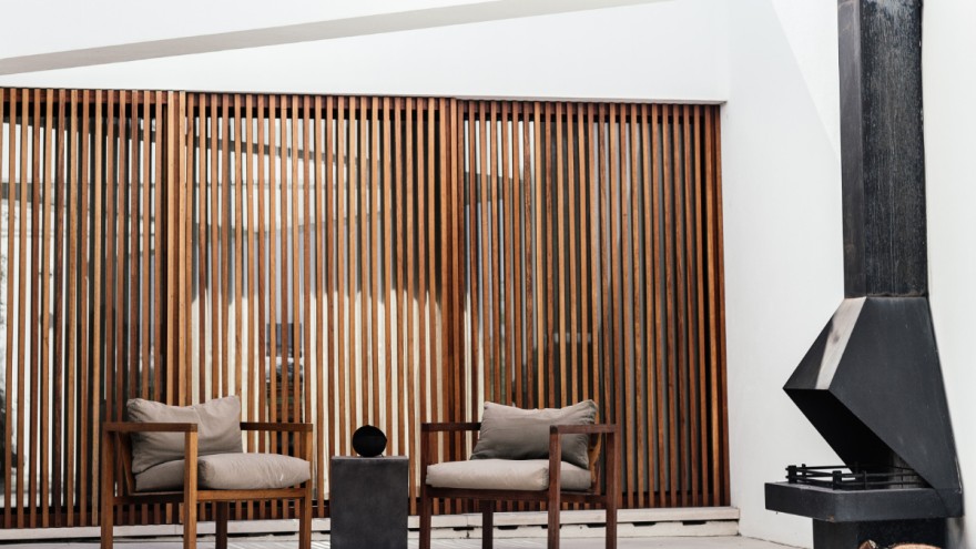Sustainable wooden chairs in front of stylish privacy screen by Dario Gomez on Unsplash
