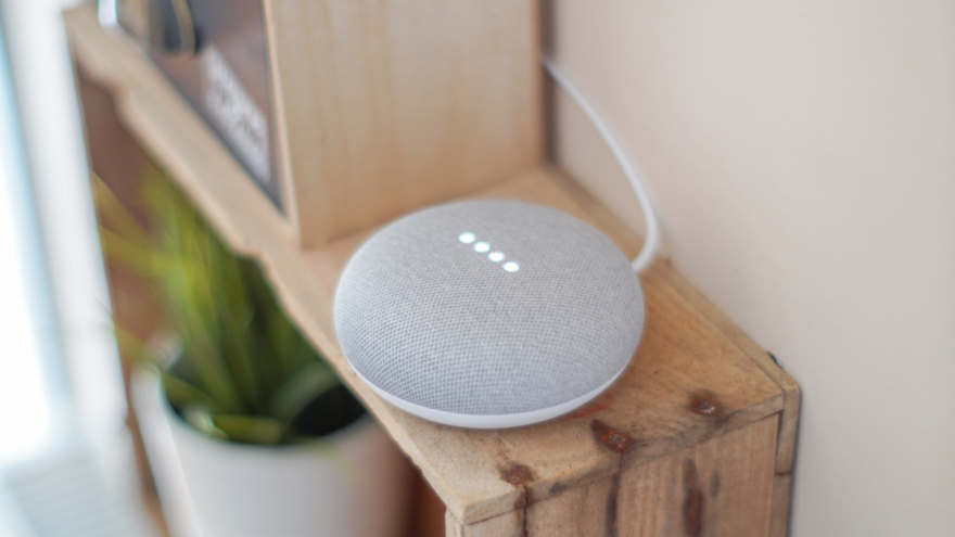 Gray Google Nest speaker on a wooden shelf Gray Google Nest speaker on a wooden shelf
