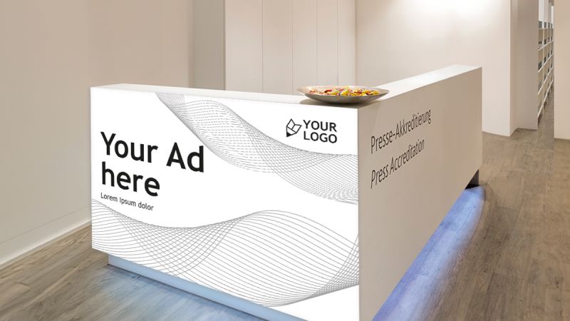 White reception desk in the press center with placeholder for advertising and the text ‘Press accreditation’ on the side