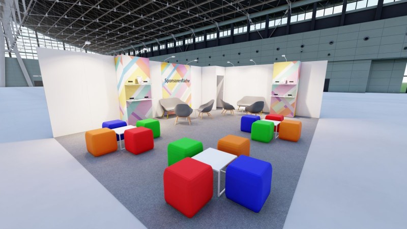 Lounge area with white cube stools and black armchairs, signposted as “Recharge Area” with colourful geometric patterns