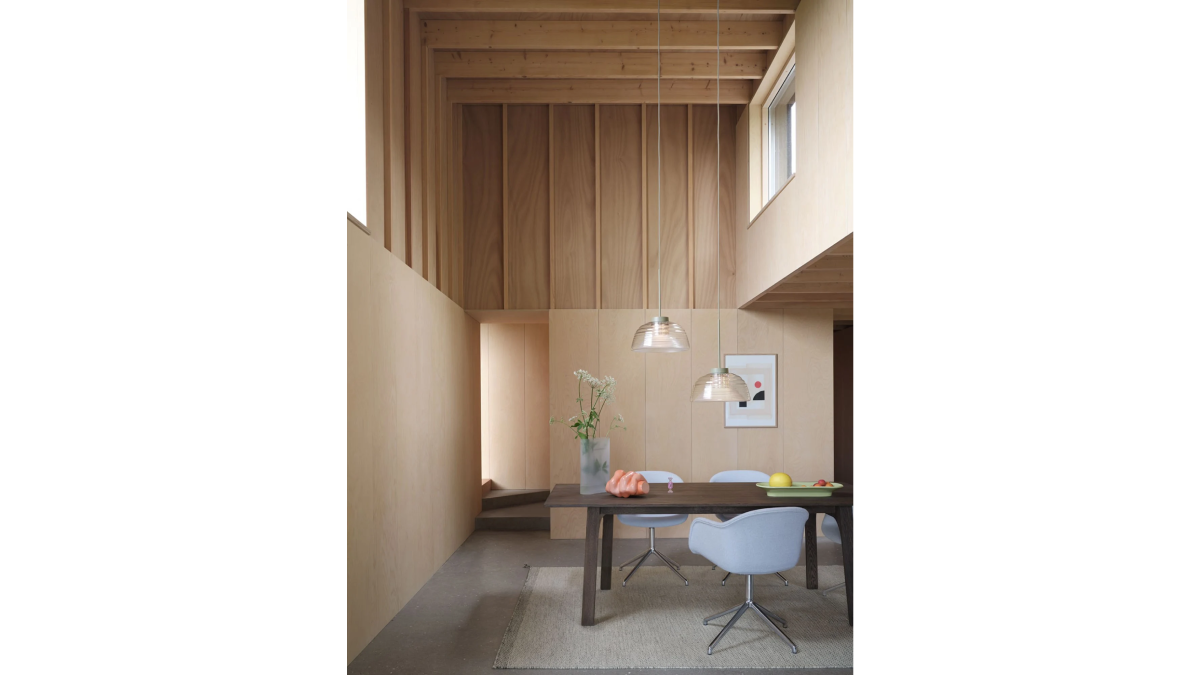 Zwei zweischichtige Pendelleuchte von Muuto hängen über einem Esstisch in einem stilvollen Ambiente.