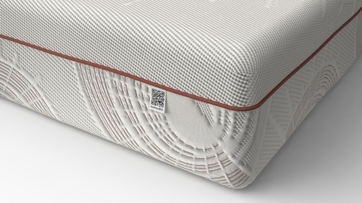 Close-up of a mattress with textured surface and decorative piping.