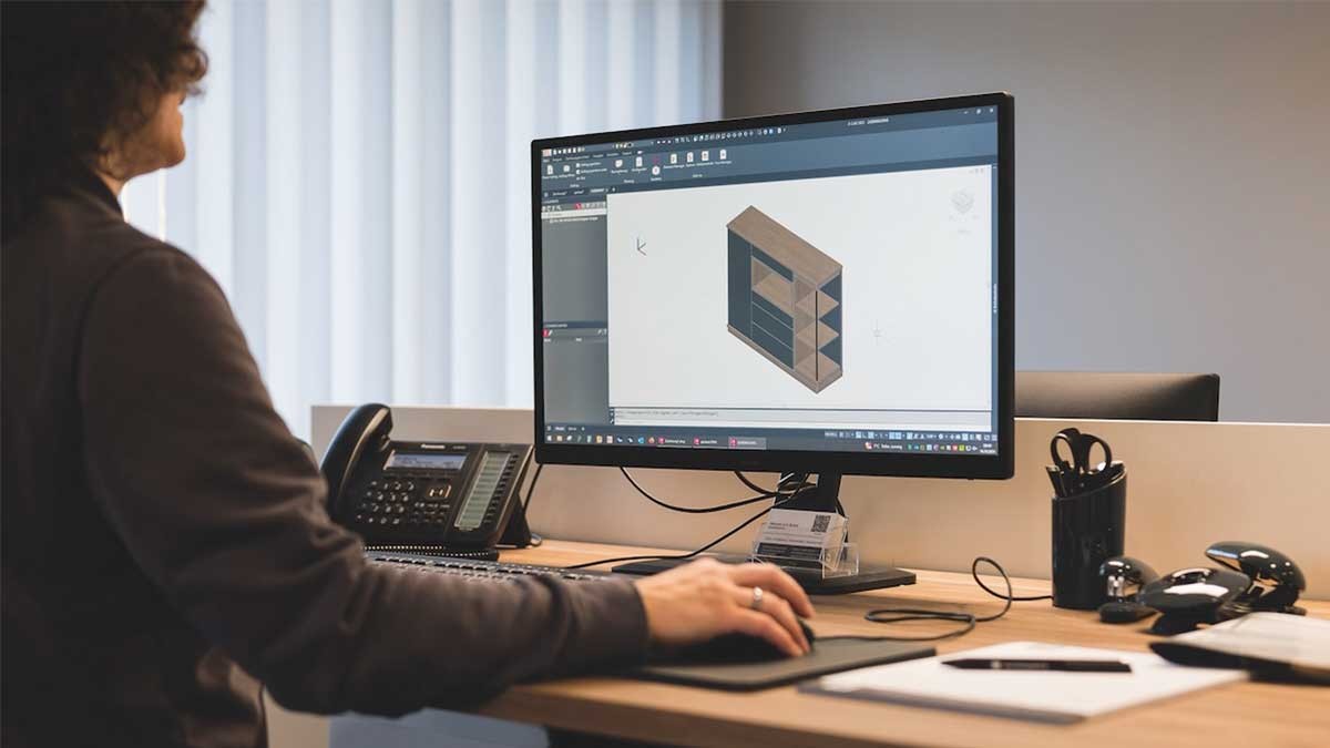 Employee works with CAD software on digital design data for automated manufacturing processes.