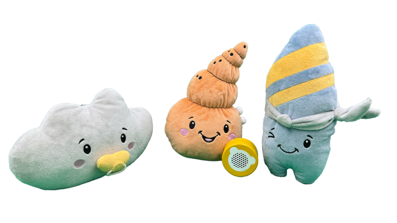 Three plush toys with smiling faces: a white cloud, an orange seashell with a yellow speaker, and a blue and yellow striped cone-shaped character