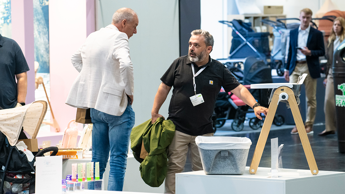 A conversation between exhibitor and visitor at Kind & Jugend