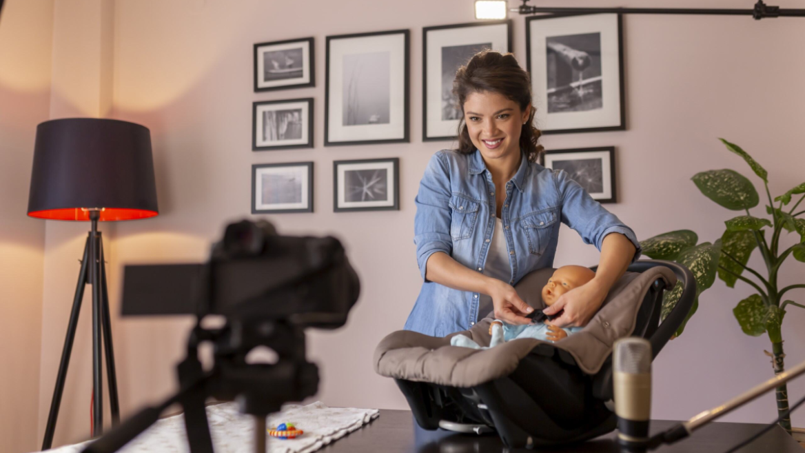 Woman films a video and presents a child car seat to the camera. (Image: vladans, iStock)Authentic content or wide reach? We explain when influencers and content creators are the right choice.