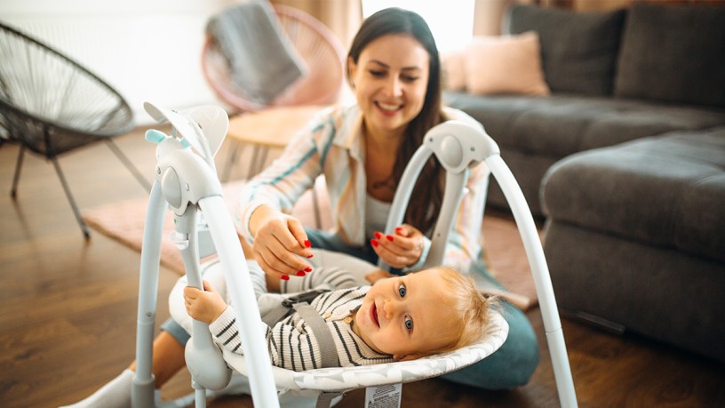 The magic of multifunctionality: young mother plays with baby in rocker
