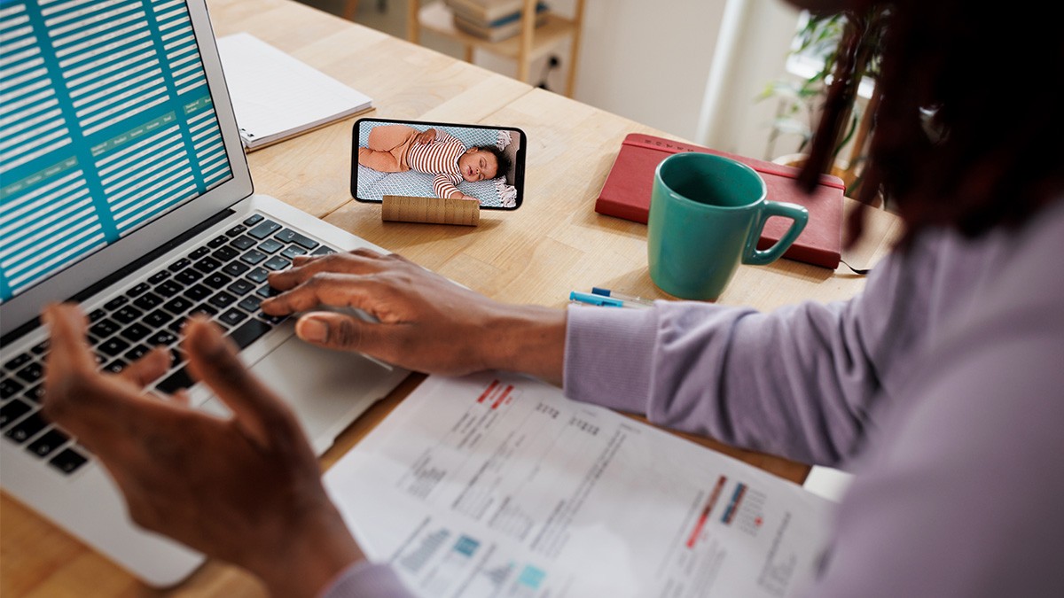 Das digitale Babyzimmer: Frau mit Smartphone neben Arbeitsplatz.