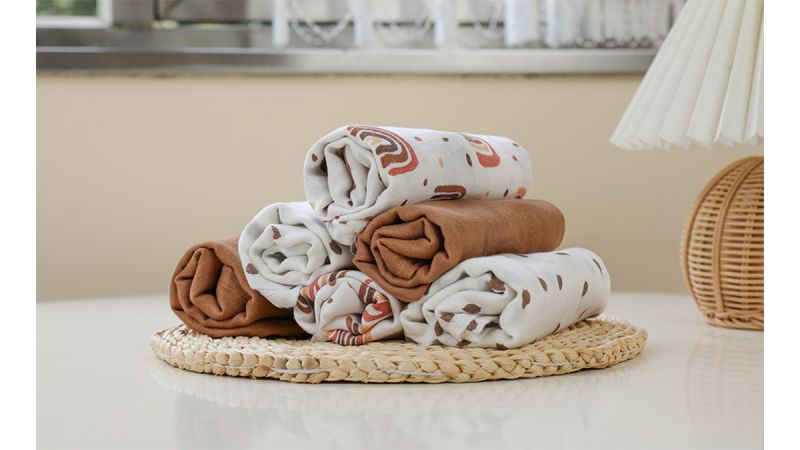 Stack of rolled brown and white patterned fabric pieces on a woven round placemat on a white surface