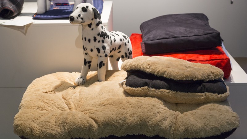 Hundefigur sitzt auf einem Hundebett aus Fell